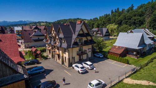 an aerial view of a large house with cars parked in a parking lot at Dunajecki Dworek in Zakopane