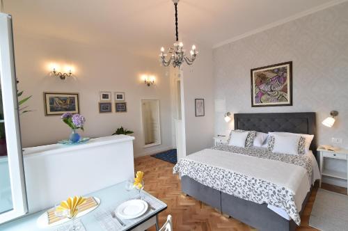 a bedroom with a large bed and a chandelier at Villa Salus, Apartment Maruna in Opatija