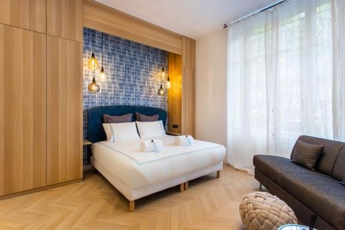 a bedroom with a large white bed and a couch at Cosy & Luxury Kléber Trocadéro Arc de Triomphe in Paris