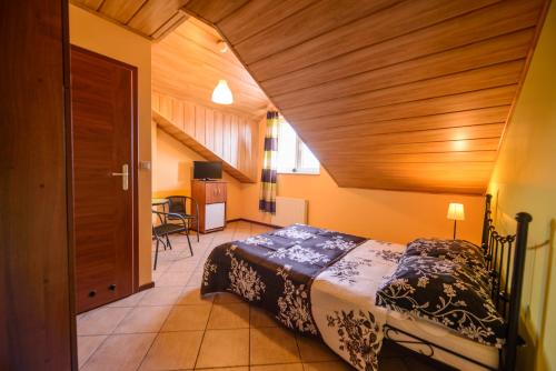ein Schlafzimmer mit einem Bett und einer Holzdecke in der Unterkunft Willa Vacanza in Łeba