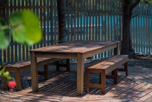 a wooden picnic table and benches in a park at Wikkid Resort in Dixon Cove