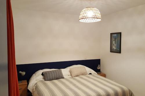 - une chambre avec un lit et un lustre dans l'établissement Gîte de Fanfan, à Barèges