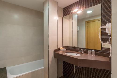 a bathroom with a sink and a mirror at Hotel Costa in El Pont de Suert