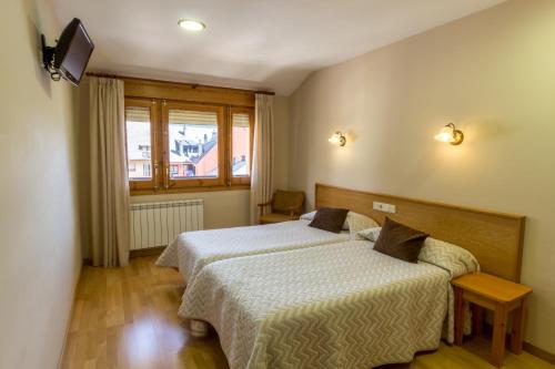 a hotel room with two beds and a window at Hotel Costa in El Pont de Suert