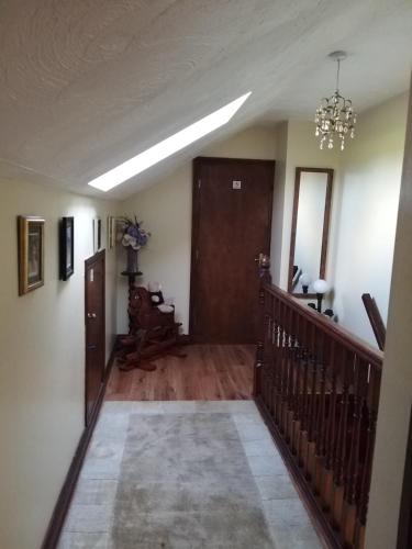 a hallway with a staircase and a chandelier at Antrim Heights Estate in Antrim
