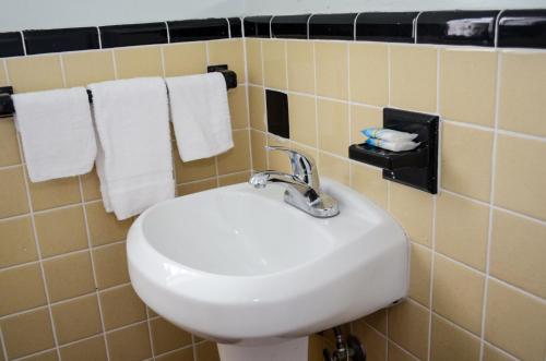 a bathroom with a white sink and towels at Economy Inn in West Palm Beach