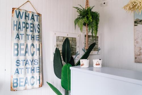 a bathroom with plants and a sign on the wall at NorthSpot in Nazaré