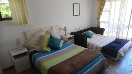 a bedroom with two beds and a window at Welterusten Guesthouse in Strand