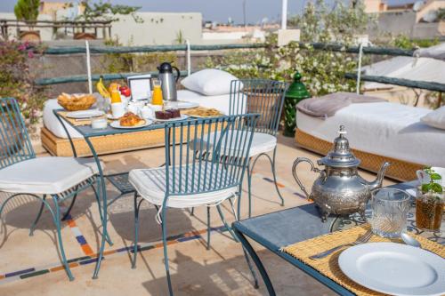 a table and chairs with food on a patio at Riad Azahar in Marrakech