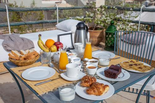 a table with breakfast foods and orange juice on it at Riad Azahar in Marrakech