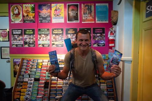 a man standing in a store holding up a book at Ocean Island Inn | Backpackers | Suites in Victoria