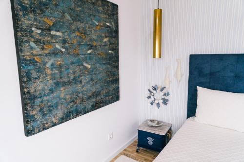 a bedroom with a bed and a painting on the wall at NorthSpot in Nazaré