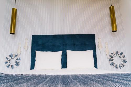 a bed with a blue head board and two pillows at NorthSpot in Nazaré