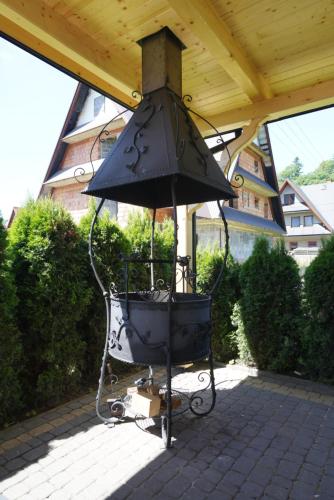 a large black bell hanging from a roof at Dunajecki Dworek in Zakopane