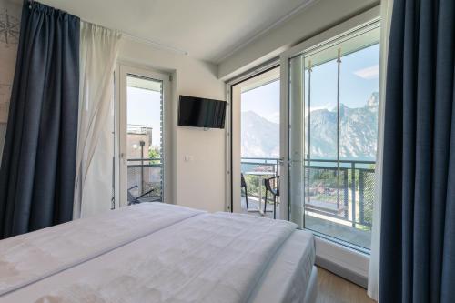 sypialnia z łóżkiem i dużym oknem w obiekcie SeeLE Garda Hotel w orbole