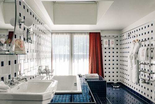 a bathroom with two sinks and a tub and a window at Experimental Chalet in Verbier