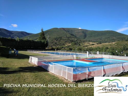 a large swimming pool with mountains in the background at Las Fontaninas in Noceda del Bierzo