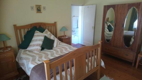 a bedroom with a bed and a large mirror at Welterusten Guesthouse in Strand