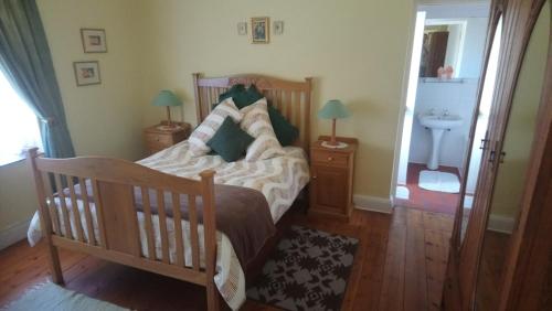 a bedroom with a wooden bed and a sink at Welterusten Guesthouse in Strand