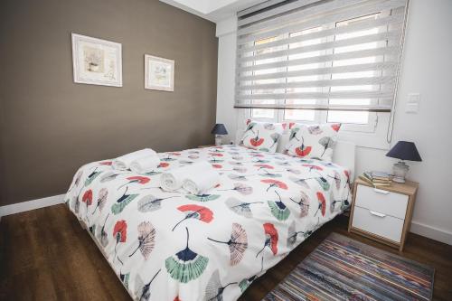a bedroom with a bed with a colorful comforter and a window at Ziva Apartment - 4th floor - Renovated 2019 in Athens
