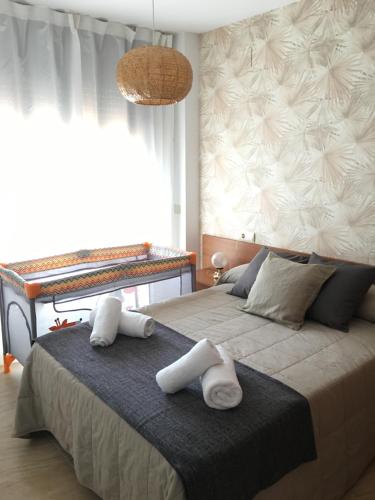 een slaapkamer met een groot bed en handdoeken bij Apartament Lo Passador in Deltebre