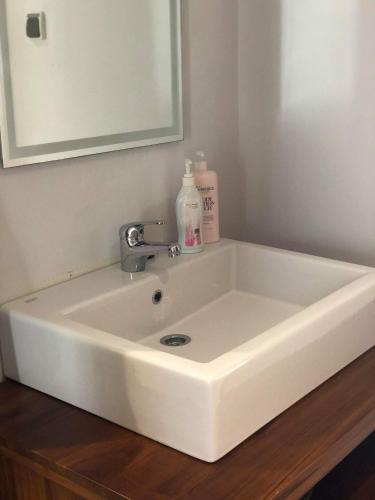 a white sink in a bathroom with a mirror at Villa Tiller 2 in Lembuak