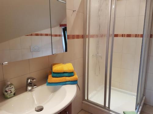 a bathroom with a sink and a shower and towels at Havel-Pension Kruse in Havelberg