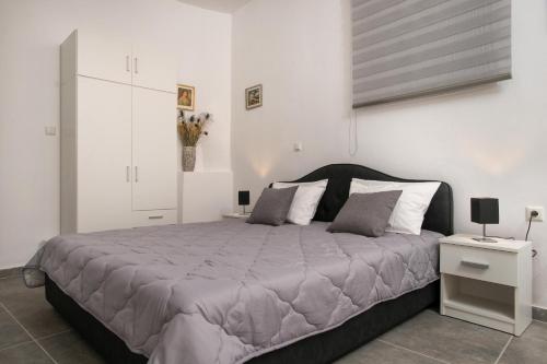 ein Schlafzimmer mit einem großen Bett und einer weißen Wand in der Unterkunft the four seasons in Korfu-Stadt