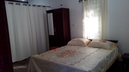 a bedroom with a bed with white sheets and a window at Family villa .hut in Tariyod