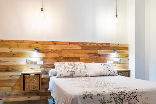 sypialnia z drewnianą ścianą i łóżkiem w obiekcie Alojamiento San Nicolas w mieście Úbeda