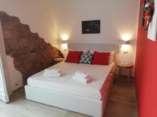 una camera da letto con un letto bianco con cuscini rossi di GH Rooms Catania a Catania