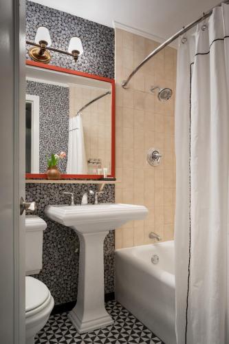 a bathroom with a sink and a tub and a toilet at Graduate by Hilton Providence in Providence