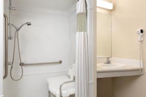 a bathroom with a shower and a sink at Days Inn by Wyndham Steinbach in Steinbach