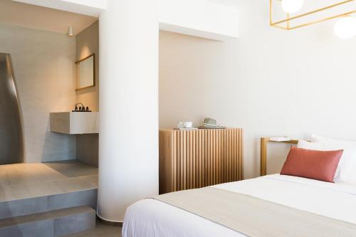 a bedroom with a white bed and a staircase at Mykonos Soul Luxury Suites in Agios Stefanos