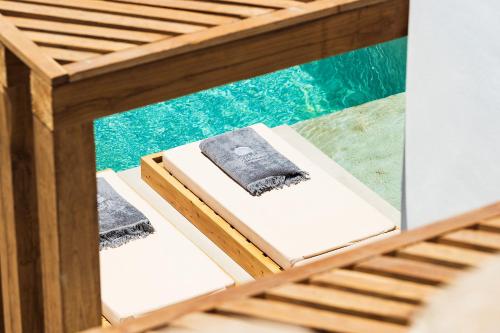a wooden bunk bed with towels on top of it at Mykonos Soul Luxury Suites in Agios Stefanos