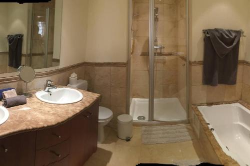 een badkamer met een douche, een wastafel en een toilet bij Bel appartement avec vue sur mer in Arona