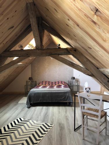 een zolderkamer met een bed en een stoel bij Le petit Candy in Amboise