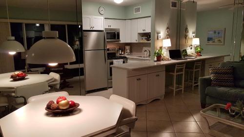a kitchen and living room with a bowl of fruit on a table at Aqua Mar Condos in Pompano Beach