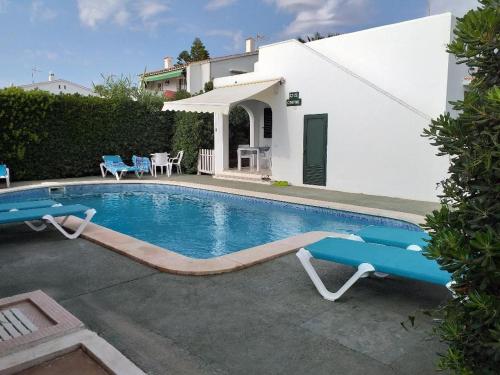 - une piscine en face d'une maison dans l'établissement Apartamentos Delfines, à Cala Blanca