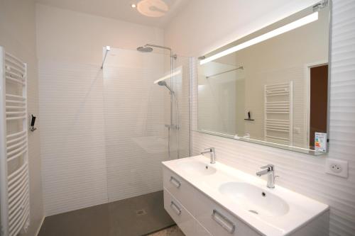 une salle de bain blanche avec un lavabo et une douche dans l'établissement Libourne Hyper Centre à deux pas de Saint Emilion, à Libourne