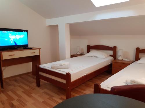 um quarto com 2 camas e uma televisão de ecrã plano em Emi em Budva