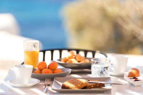 a table topped with plates of food and drinks at Mykonos Soul Luxury Suites in Agios Stefanos