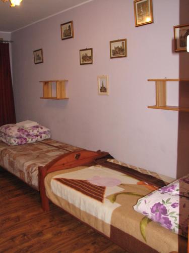a bedroom with two beds and pictures on the wall at Łosiowy Kąt in Goniadz