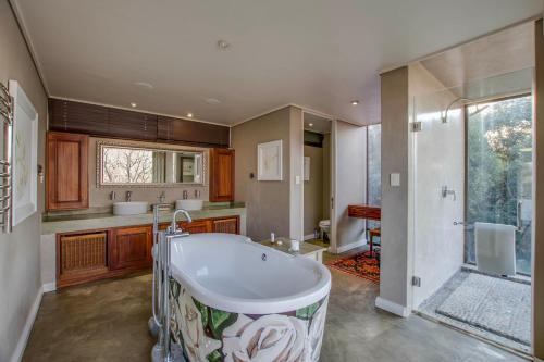 a large bathroom with a tub and a shower at Migdash Guesthouse in Hartbeespoort