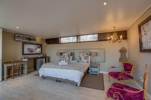 a bedroom with a bed and a table and chairs at Migdash Guesthouse in Hartbeespoort