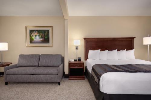 Habitación de hotel con cama y silla en Wingate by Wyndham Columbia/Lexington en Lexington