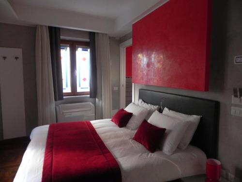 ein Schlafzimmer mit einem großen Bett mit roten und weißen Kissen in der Unterkunft Gente di Notte in Frascati