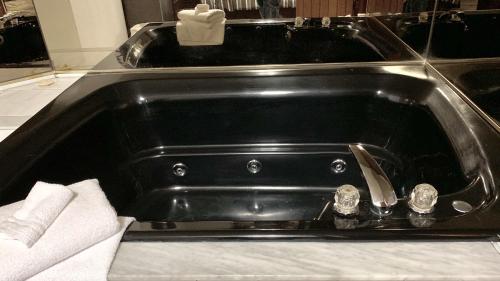 a black bath tub with two clocks in it at Deluxe Inn in Toronto