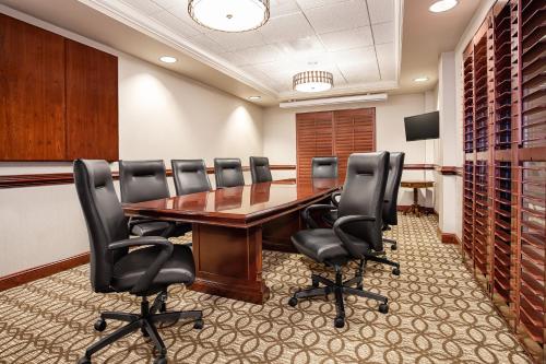 a conference room with a wooden table and black chairs at Wingate by Wyndham Columbia/Lexington in Lexington