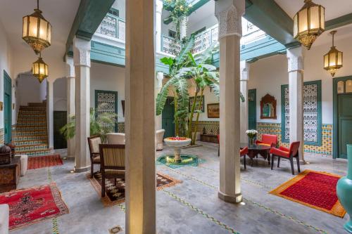 eine Lobby eines Gebäudes mit Tischen und Stühlen in der Unterkunft Riad Azahar in Marrakesch